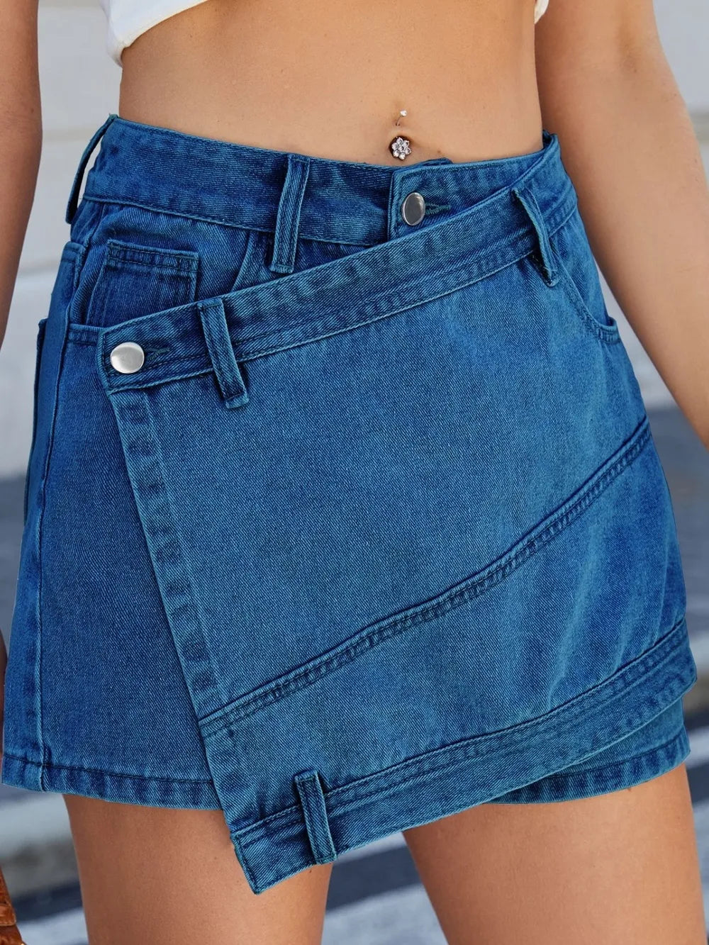 Blue denim skirt worn by a person with a blurred background