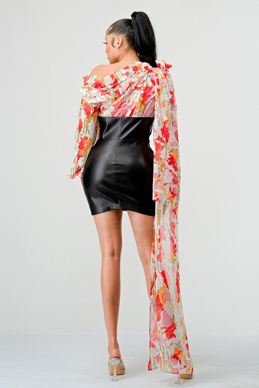 a woman in a black leather mini skirt and a floral print off-the-shoulder top with dramatic sleeves.