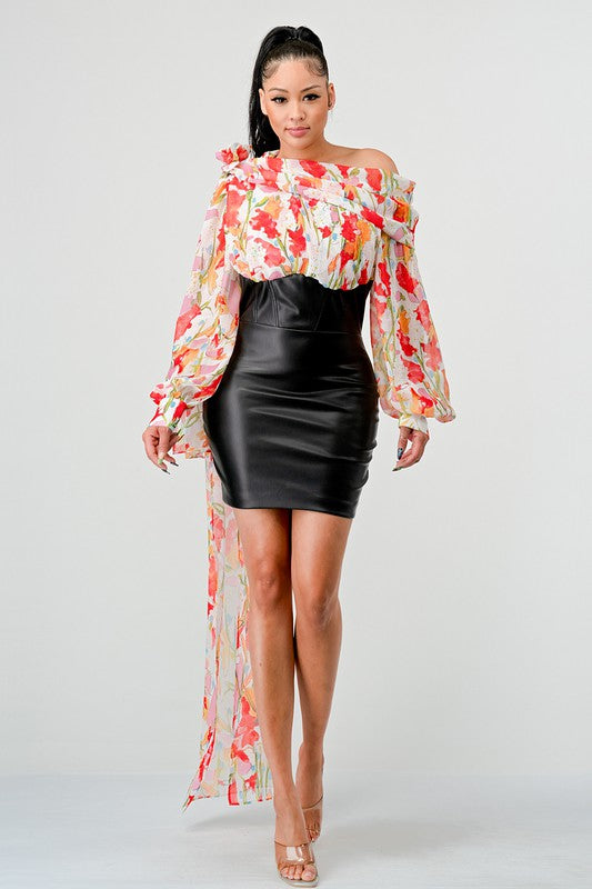 a woman in a black leather mini skirt and a floral print off-the-shoulder top with dramatic sleeves.