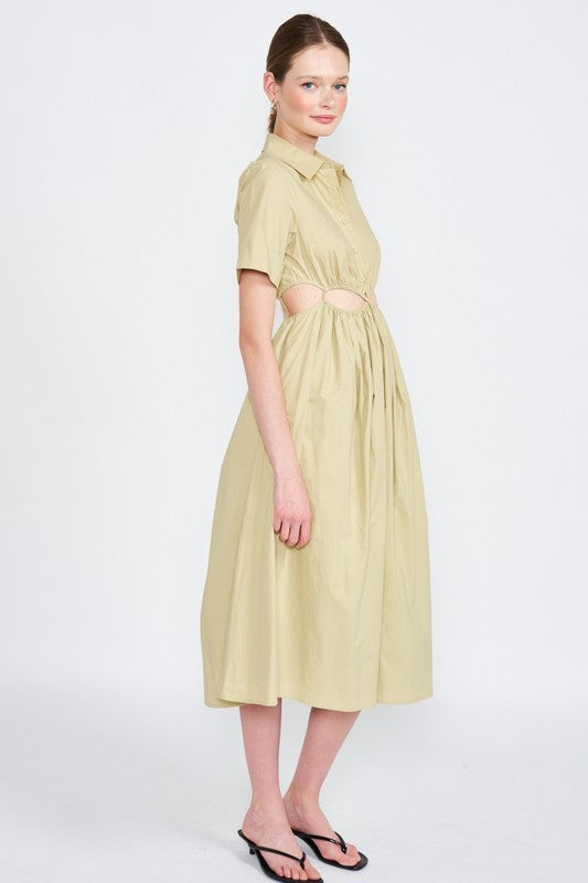 Woman models a stylish olive green midi dress with a collar, short sleeves, and fashionable cut-outs, side view.
