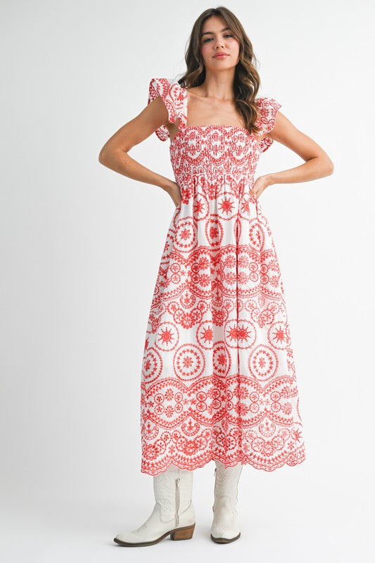 The dress is a long, airy maxi with a blue and white geometric/medallion print, cap sleeves, and a fitted bodice that flows into a relaxed, ankle-length skirt.