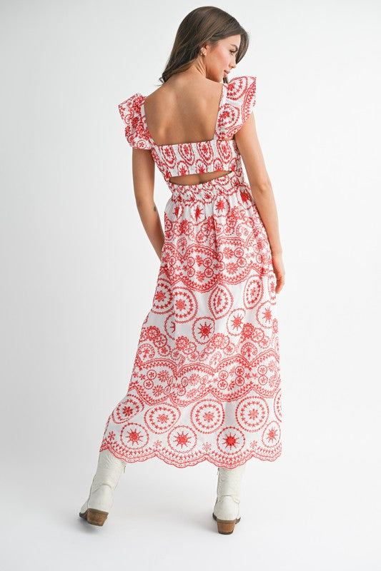 The dress is a long, airy maxi with a blue and white geometric/medallion print, cap sleeves, and a fitted bodice that flows into a relaxed, ankle-length skirt.