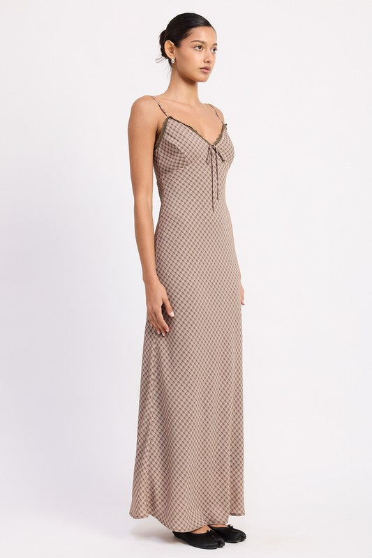 the dress is a form-fitting, floor-length maxi with a soft, neutral taupe color and a delicate, textured fabric