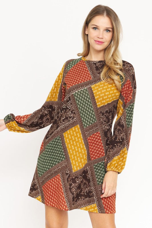 A color-blocked patchwork dress with bold, geometric patterns in red, orange, blue, and black, creating a vibrant, eclectic look.