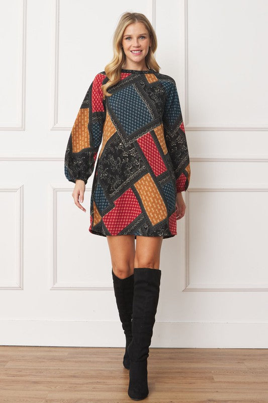 A color-blocked patchwork dress with bold, geometric patterns in red, orange, blue, and black, creating a vibrant, eclectic look.