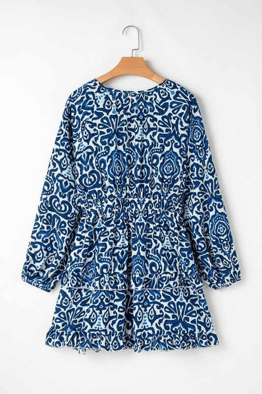 Boho-lace-up v-neck dress hanging in a plain background.