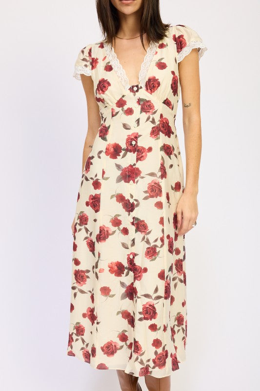 Woman models a vintage-inspired cream midi dress with red rose print, front portrait view.