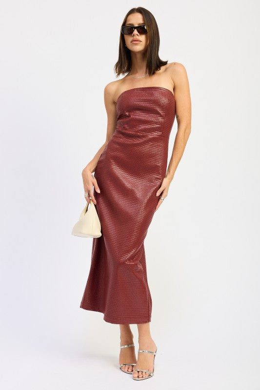 A woman models a sleek, strapless midi dress with a textured finish, ideal for a chic evening look, posing stylishly.