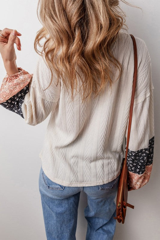 Floral patchwork design mixed with cable-knit texture gives a rich, layered look.