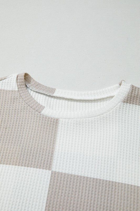 Close-up of a textured shirt with a checkered pattern on a light gray background