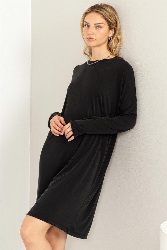 A woman models a black, comfortable oversized Midi Dress with a relaxed fit, perfect for casual wear.