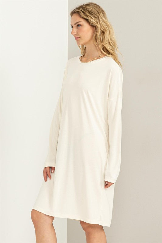 A woman models a white, comfortable oversized Midi Dress with a relaxed fit, perfect for casual wear, side view.
