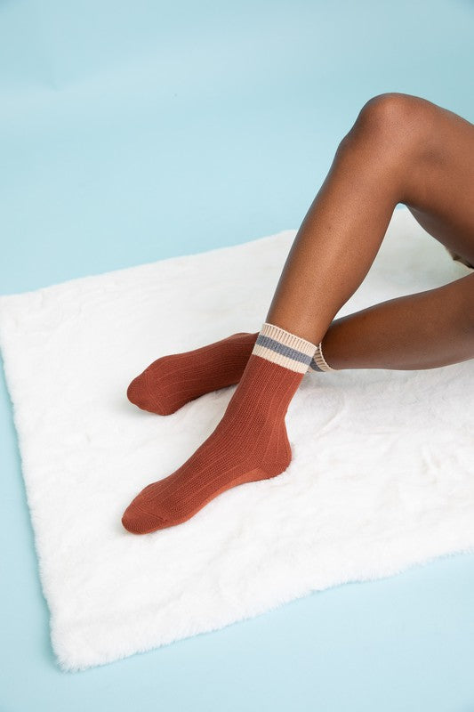 Rust ribbed crew socks with striped cuffs, adding a warm tone to the collection.