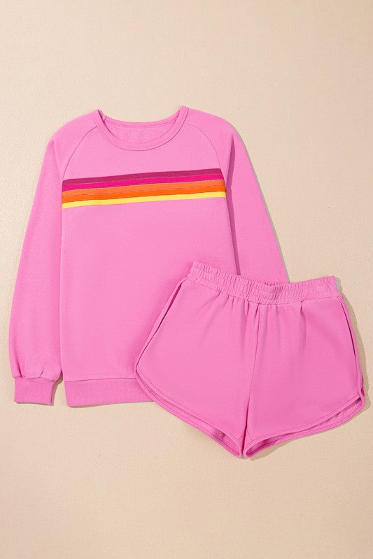 Pink sweatshirt and shorts set with colorful stripes on a beige background