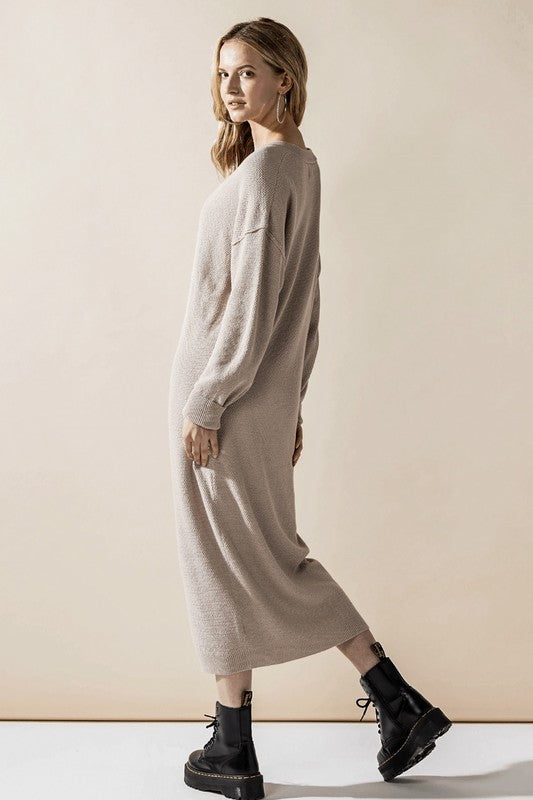 Woman wearing a button-front sweater midi dress with long sleeves and henley neckline.