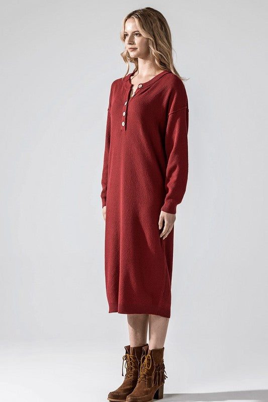 Woman wearing a button-front sweater midi dress with long sleeves and henley neckline.