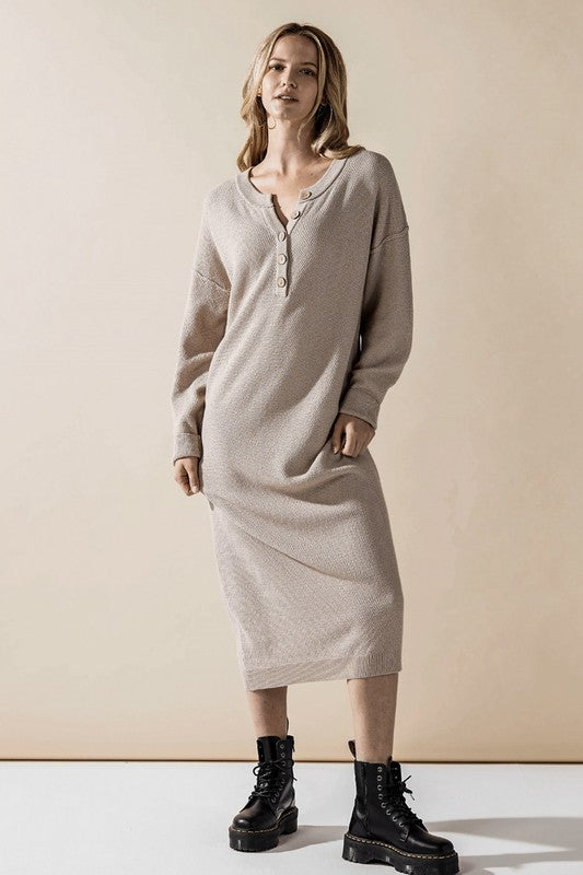 Woman wearing a button-front sweater midi dress with long sleeves and henley neckline.