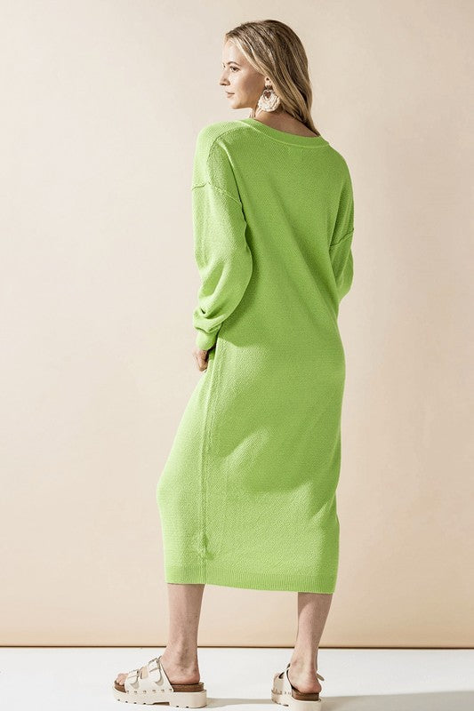 Woman wearing a button-front sweater midi dress with long sleeves and henley neckline.