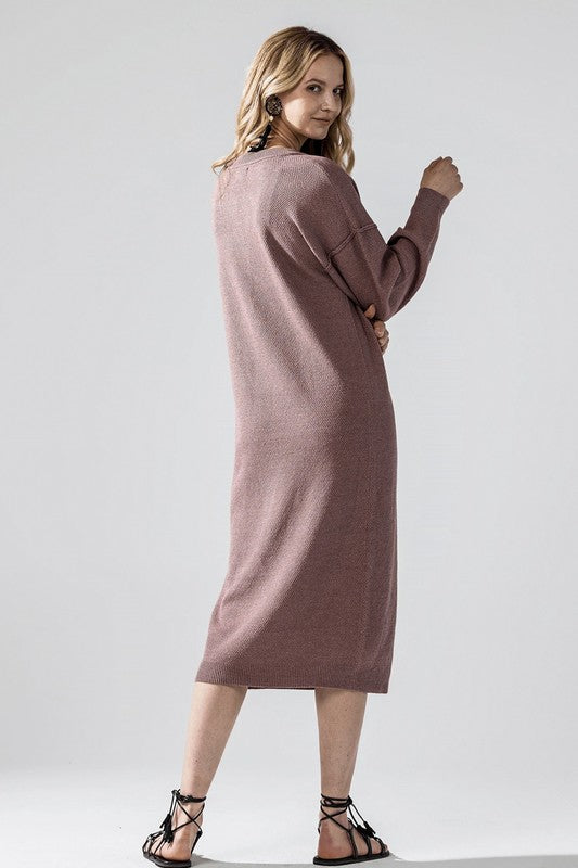 Woman wearing a button-front sweater midi dress with long sleeves and henley neckline.