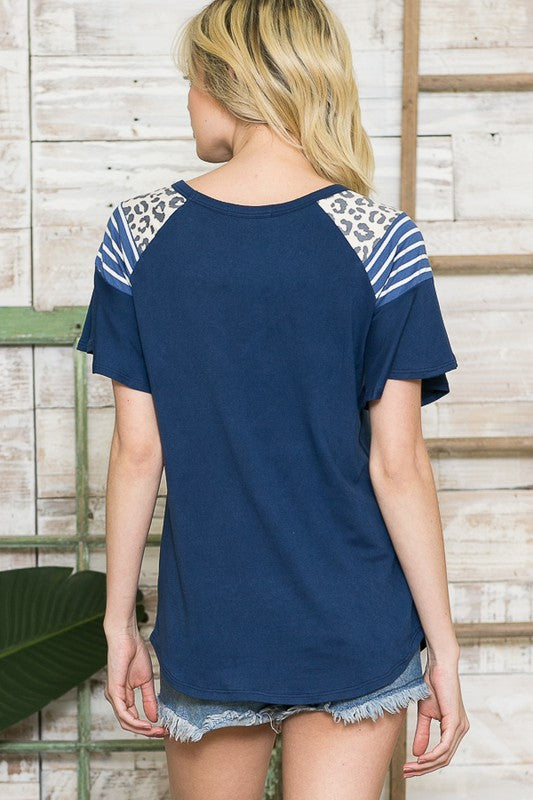 A versatile top combining cozy knit and standout ruffle sleeves with fabric contrast.