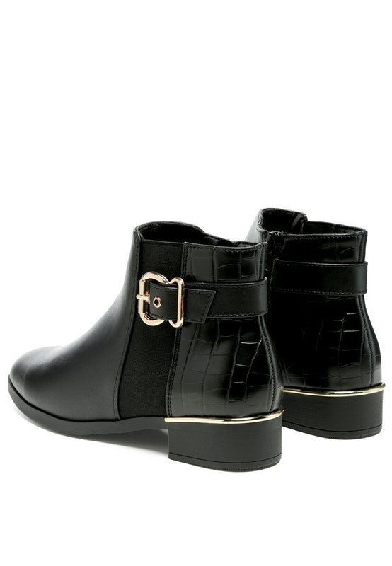 A black decorative strap with a gold-tone buckle runs around the outer side near the ankle.