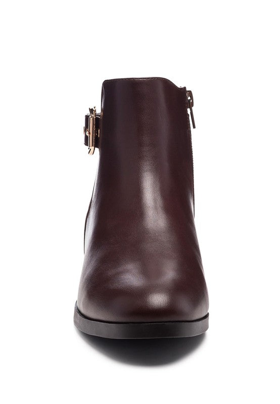 A decorative strap with a gold-tone buckle runs around the outer side near the ankle.