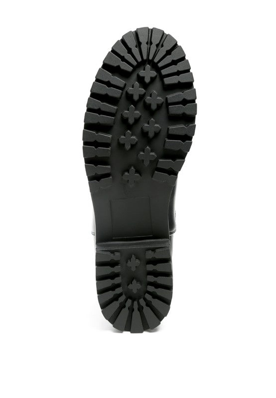 A black decorative strap with a gold-tone buckle runs around the outer side near the ankle.