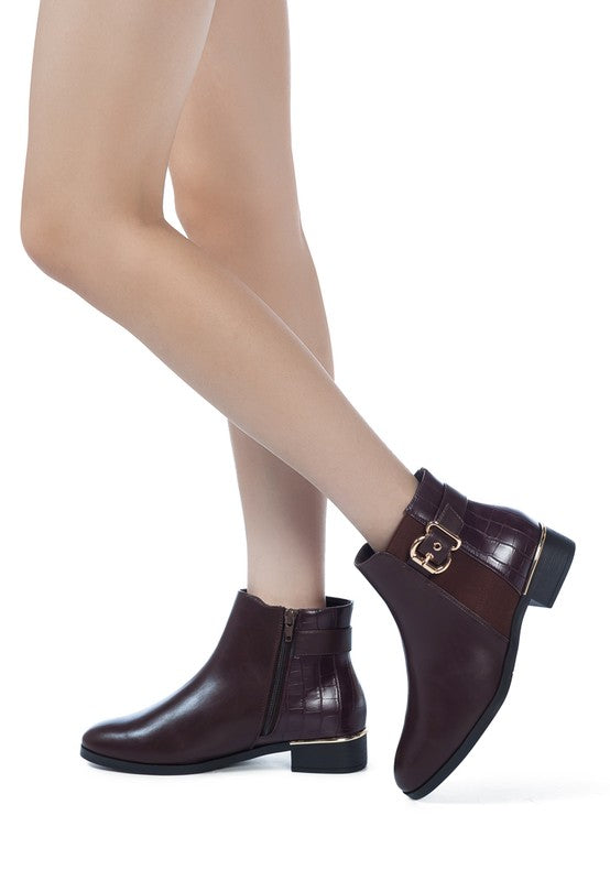 A decorative strap with a gold-tone buckle runs around the outer side near the ankle.