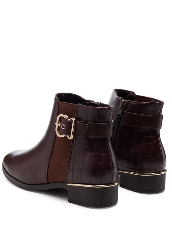 A decorative strap with a gold-tone buckle runs around the outer side near the ankle.