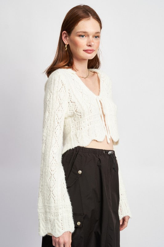 Romance and texture unite in this crochet crop with bell sleeve flair.