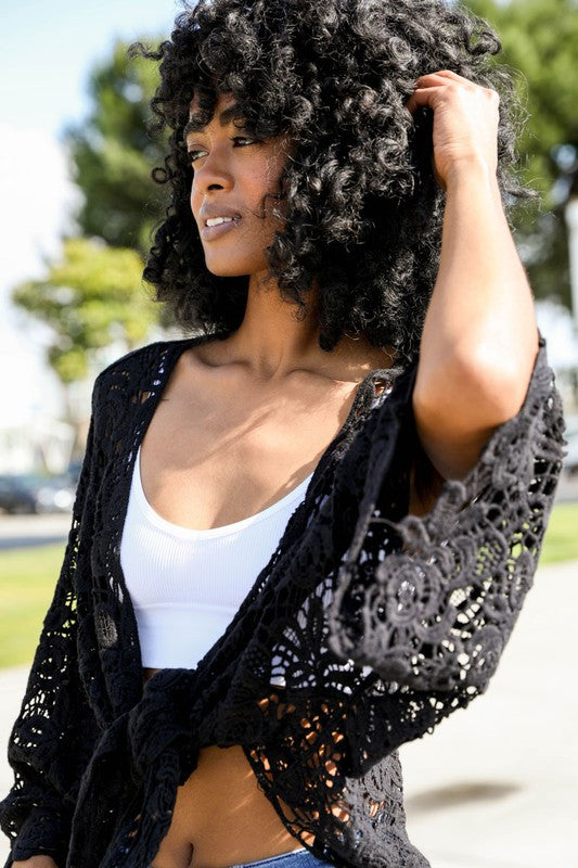 Romantic crochet patterns blend with wrap structure for a unique look.