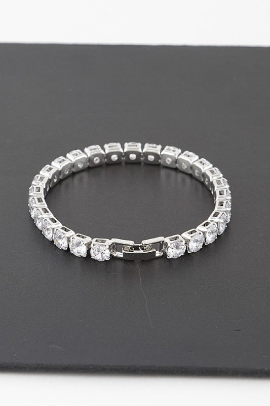 Silver tennis bracelet adorned with round-cut clear gemstones, set in a continuous row for an elegant and classic look.
