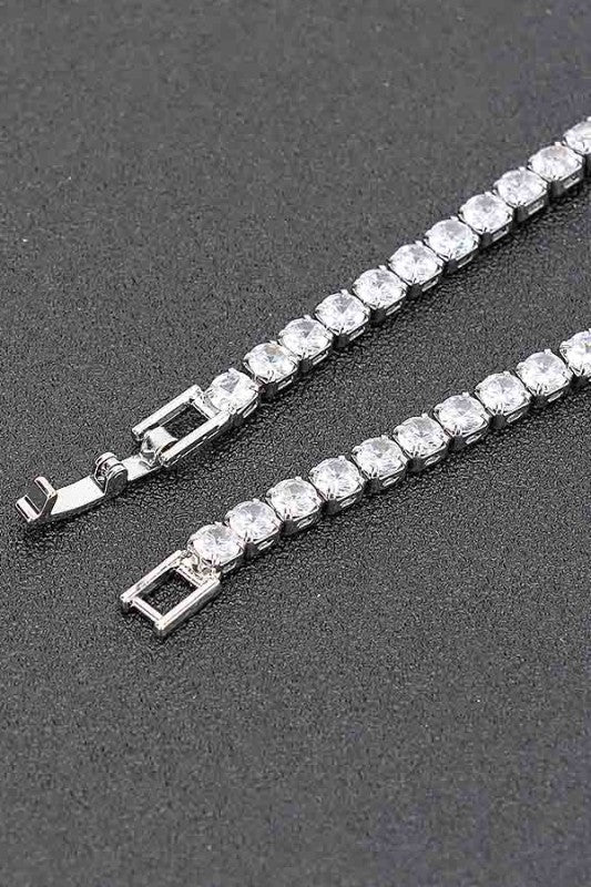 Gold tennis bracelet adorned with round-cut clear gemstones, set in a continuous row for an elegant and classic look.
