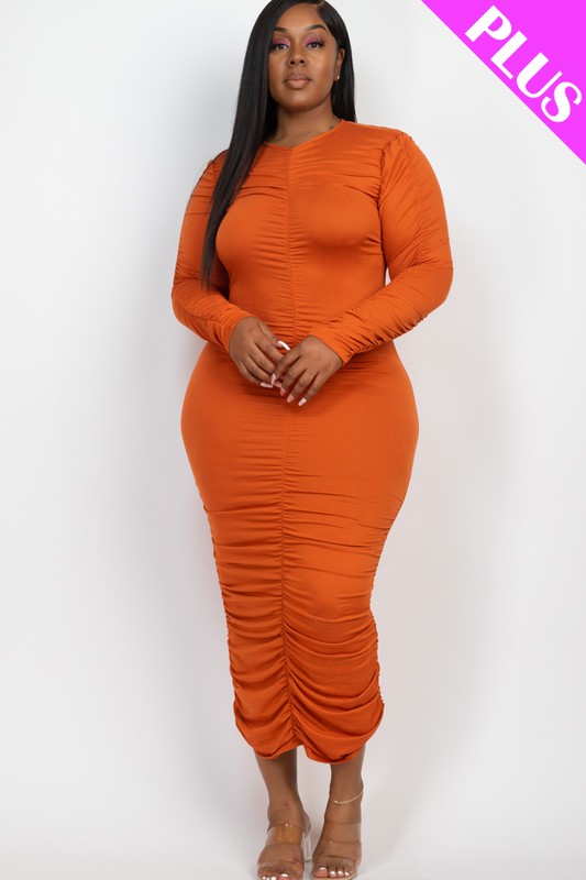 A model wears a stylish orange ruched midi dress with long sleeves, offering a comfortable and trendy fit.