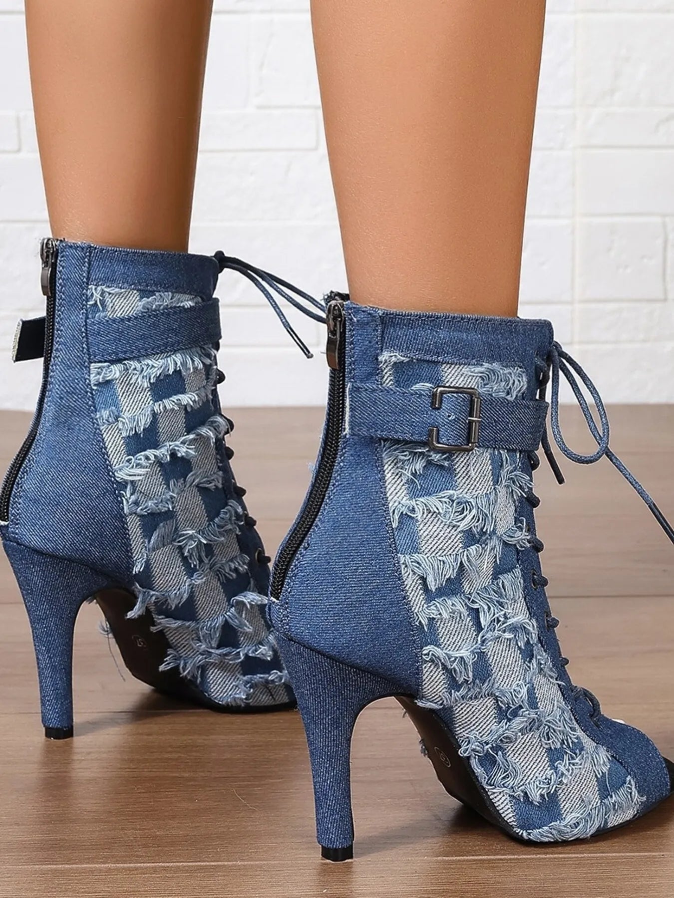 Denim peep-toe ankle booties with lace-up front, distressed frayed edges, ankle strap buckle, and stiletto heel