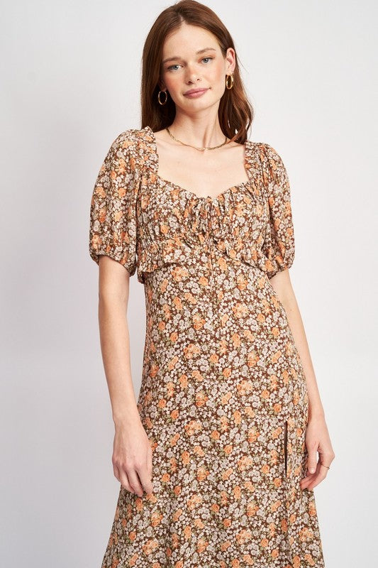 Woman models a chic floral midi dress with puff sleeves, a sweetheart neckline, and a trendy high slit, perfect for spring/summer, knee length view.