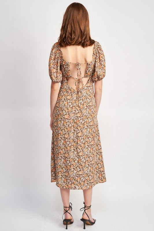 Woman models a chic floral midi dress with puff sleeves, a sweetheart neckline, and a trendy high slit, perfect for spring/summer, back view.