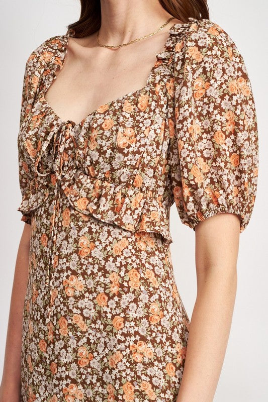 Woman models a chic floral midi dress with puff sleeves, a sweetheart neckline, and a trendy high slit, perfect for spring/summer, close up.