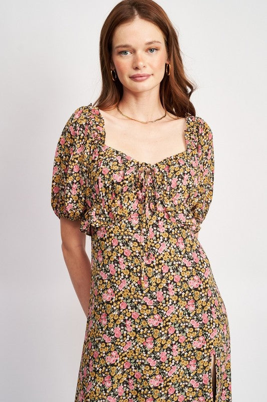 Woman models a chic floral midi dress with puff sleeves, a sweetheart neckline, and a trendy high slit, perfect for spring/summer, portrait view.