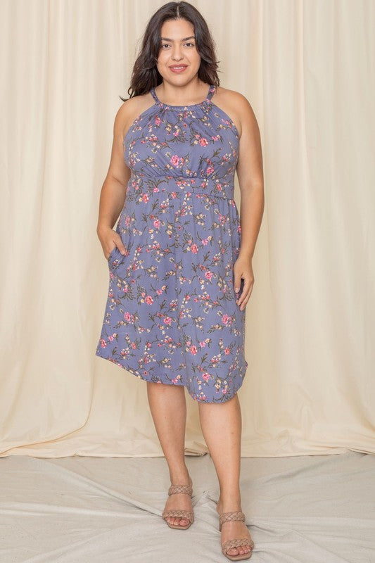 Woman wearing a floral halter neck midi dress with a flared skirt.