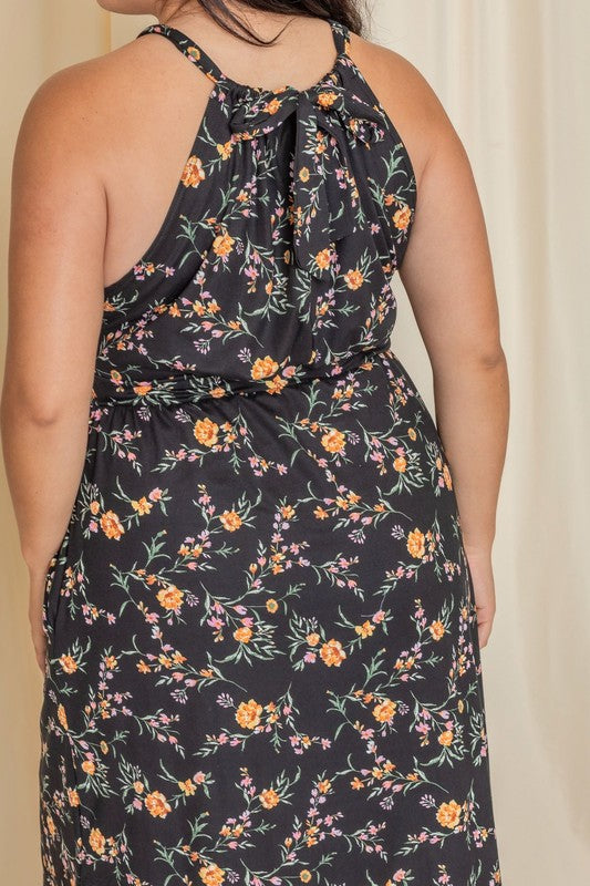 Woman wearing a floral halter neck midi dress with a flared skirt.