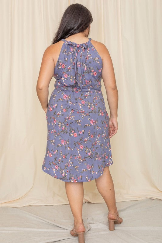 Woman wearing a floral halter neck midi dress with a flared skirt.