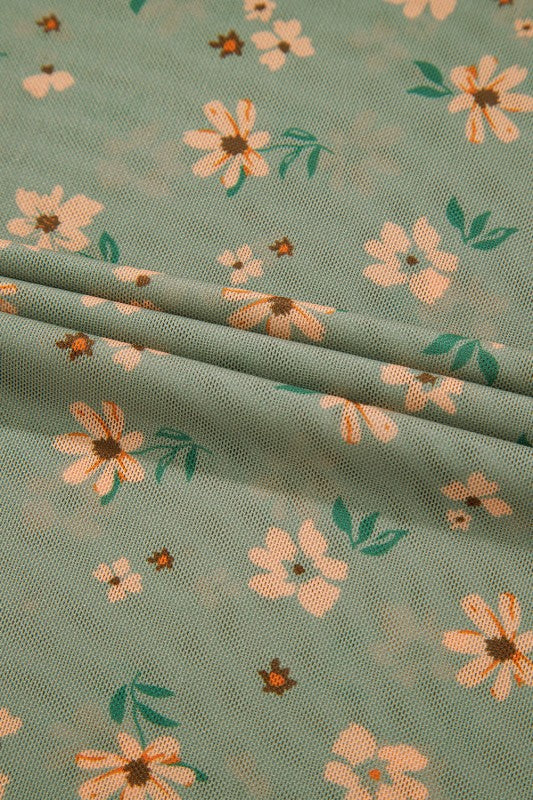 A sheer green floral top placed beautifully.