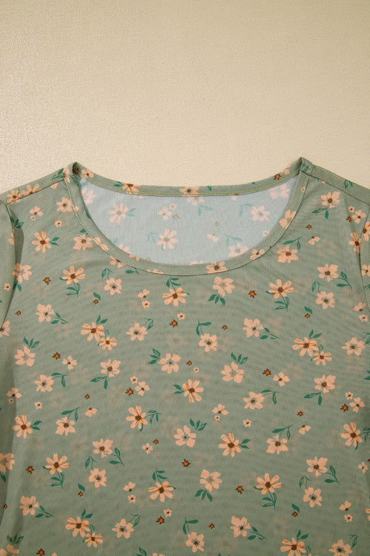 A sheer green floral top hanging beautifully.