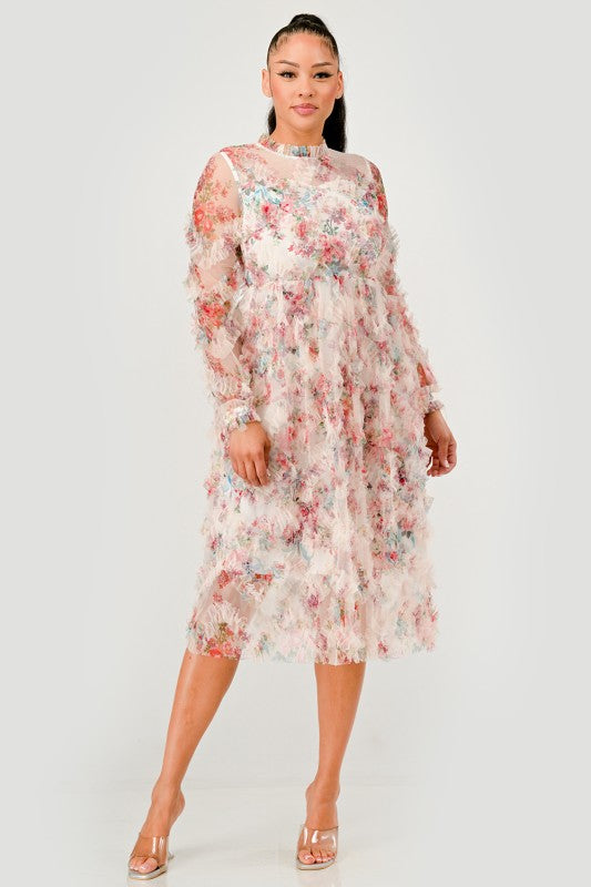 A woman models an elegant floral midi dress with sheer long sleeves, a high neck, and textured ruffled details for a romantic look.