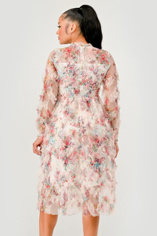 A model wearing an elegant floral midi dress with sheer long sleeves, a high neck, and textured ruffled details for a romantic look.