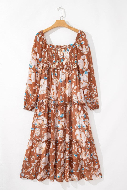 Floral patterned dress on a hanger against a white background