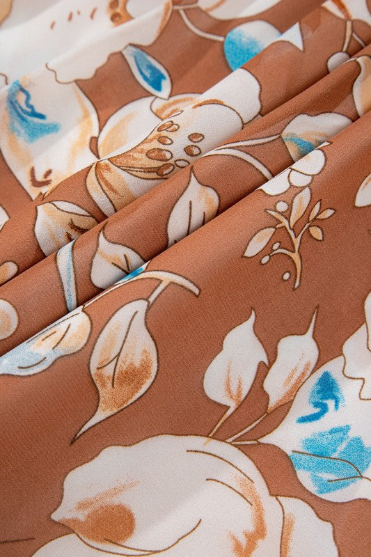 Close-up of floral fabric with brown, white, and blue colors on a brown background.