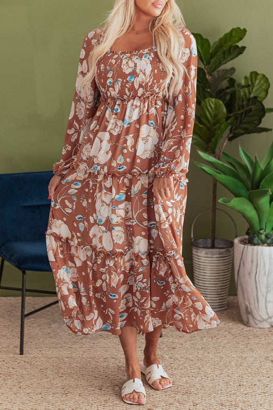 Woman wearing a floral dress standing in a room with plants.