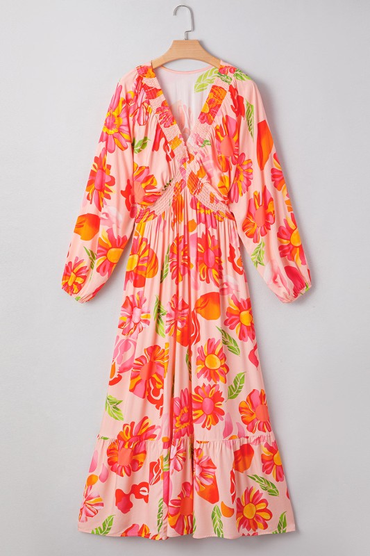 A flowy maxi dress with a vibrant floral print in pink, orange, and green.